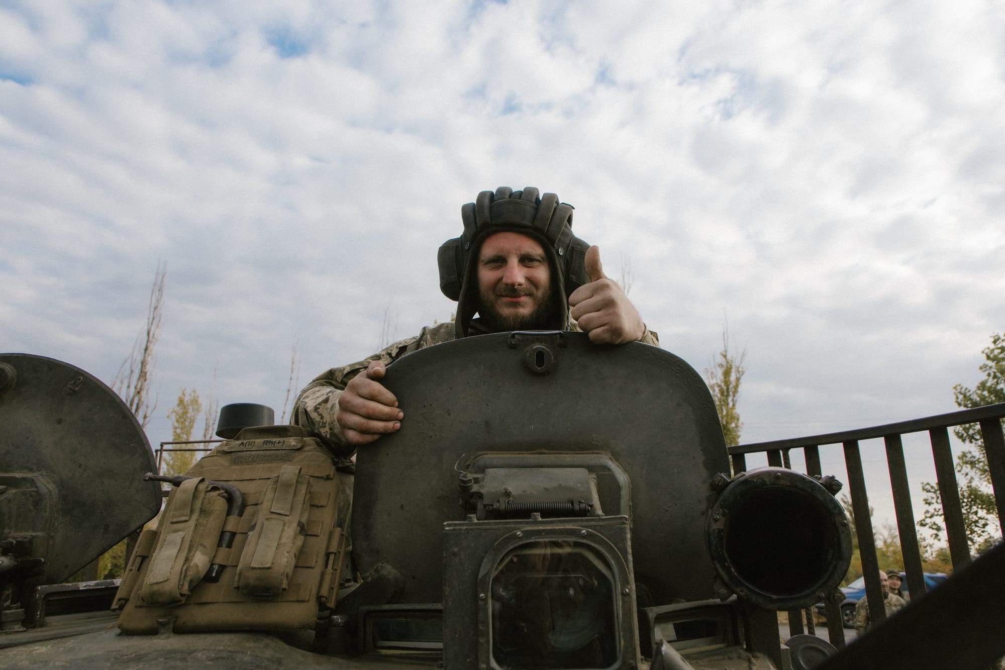 Ukrainian soldier giving the thumbs-up from inside a tank